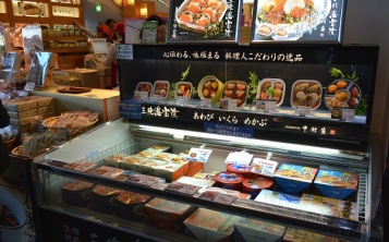 Replicas of fresh cooked food in a showcase with frozen foods attract customers’ attention.