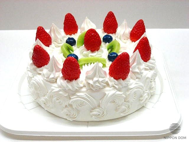 A replica of cake with kiwi, strawberry and bilberry