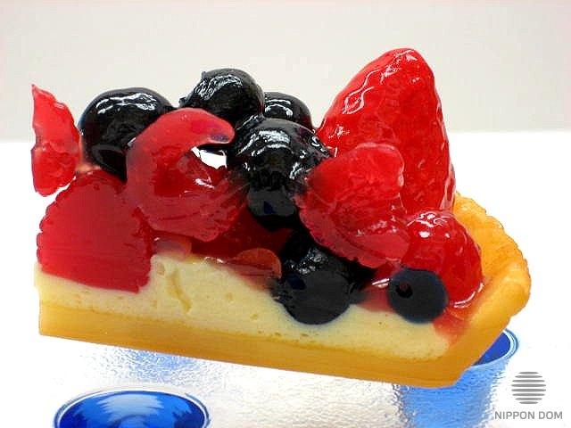 A replica of cheesecake with cranberries, blueberries, raspberries, strawberries