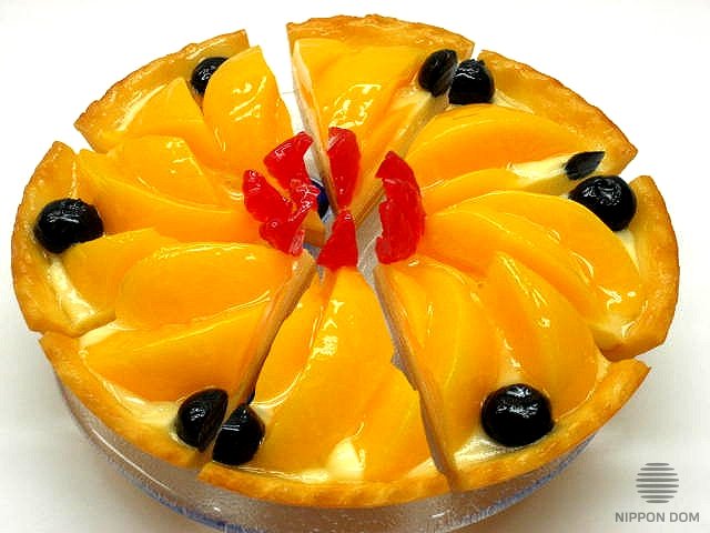 A model of cheesecake with peach and blueberries