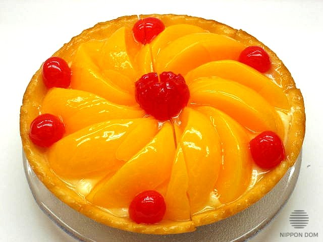 A model of cheesecake with peach and cranberries