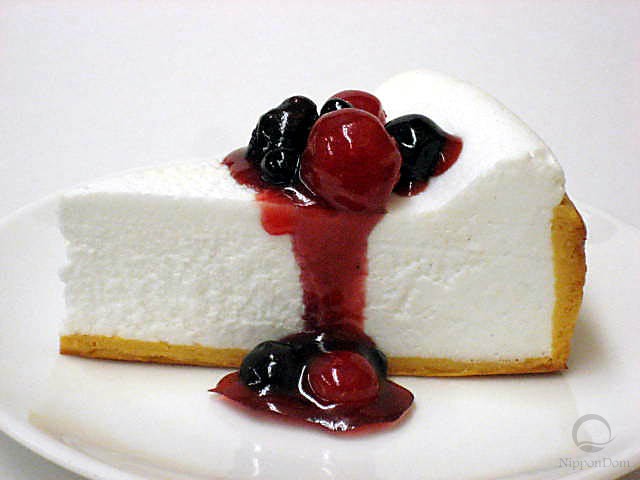 A replica of cheesecake with berry sauce